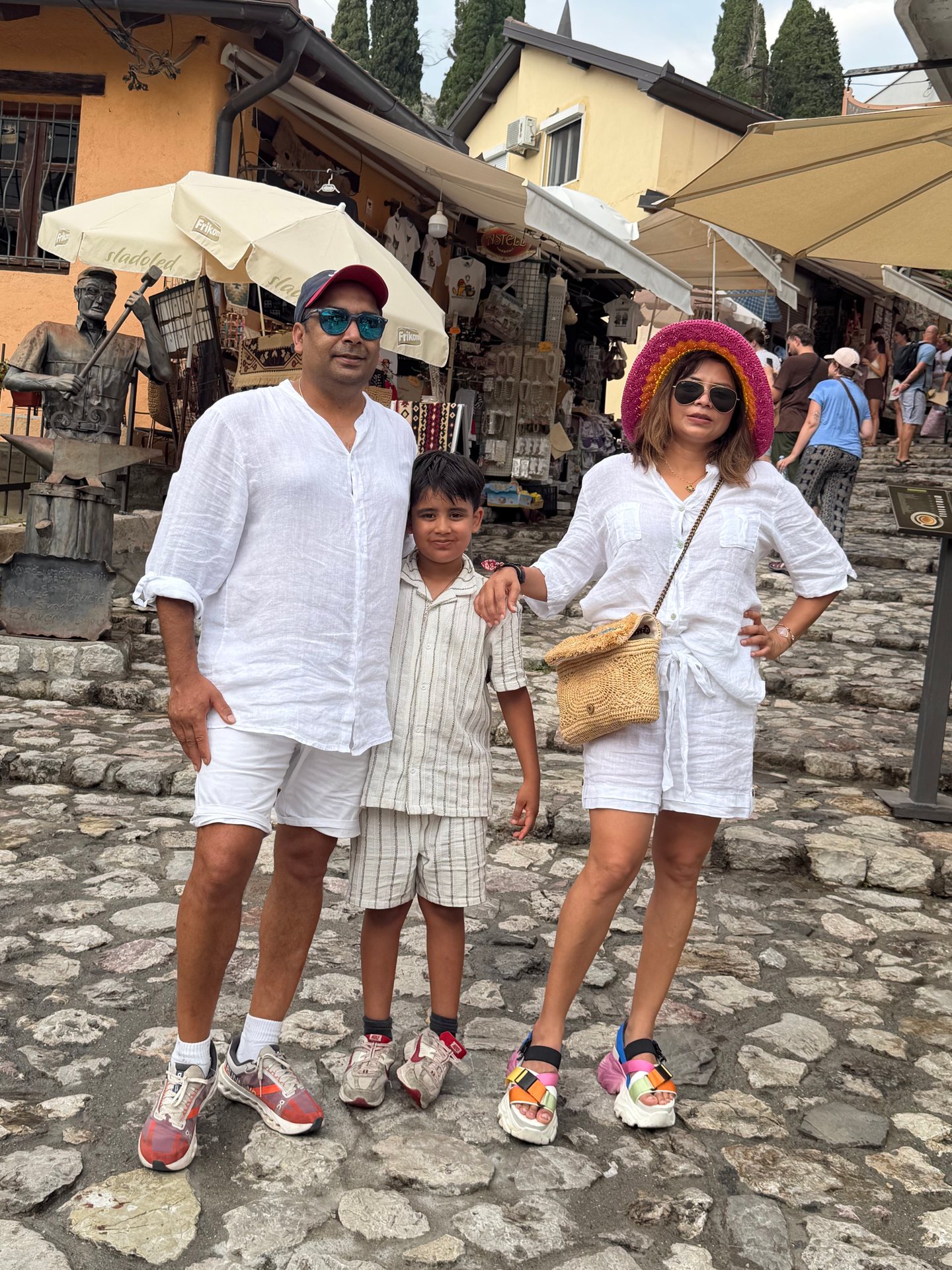Our family standing together on cobbled steps among colourful market stalls.